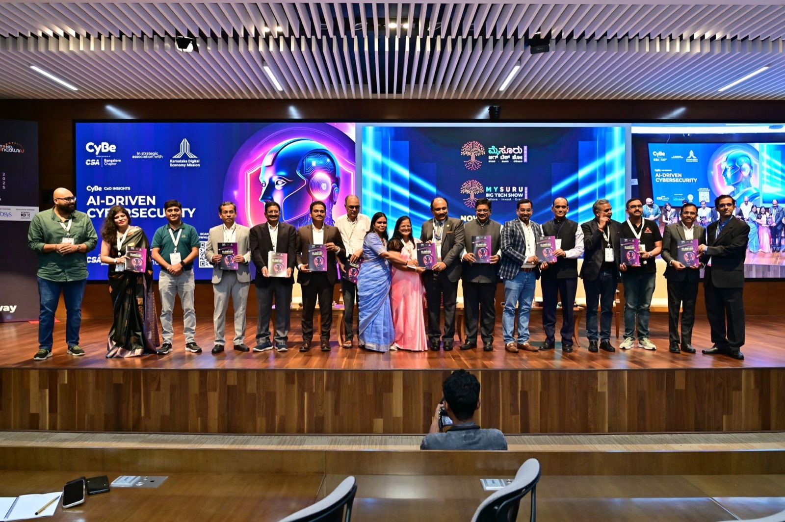 Contributors on stage holding copies of the AI-Driven Cybersecurity report at its launch